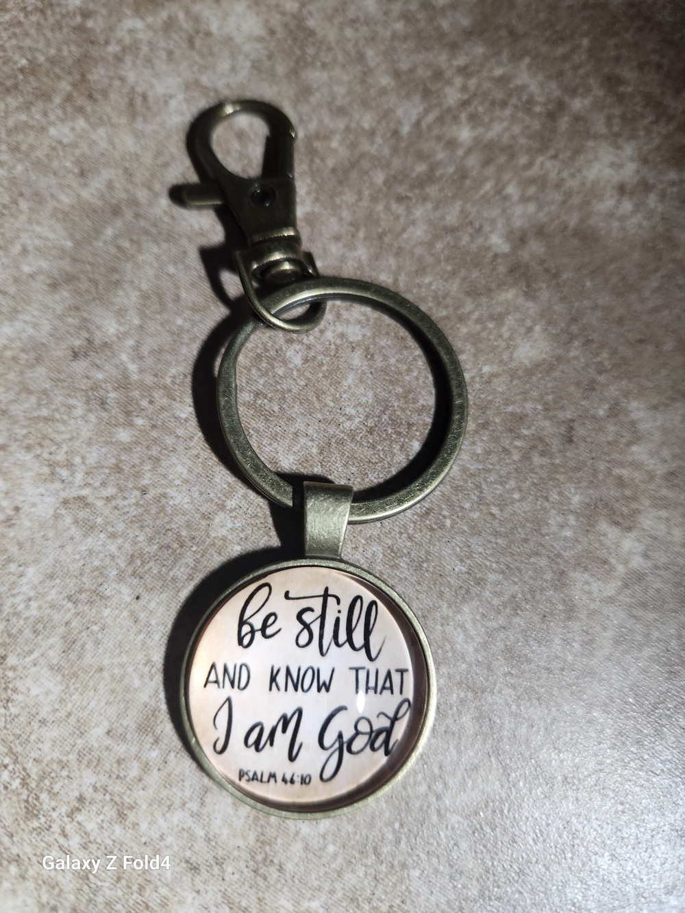 Hand Crafted brass-tone 'Be Still and Know' keychain - beige/black